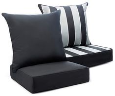 two black and white pillows sitting next to each other on top of a chair cushion