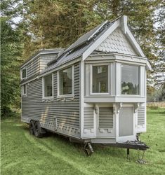 a tiny house on wheels is parked in the grass