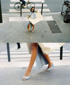 a woman sitting on a bench in the middle of a crosswalk with her legs crossed