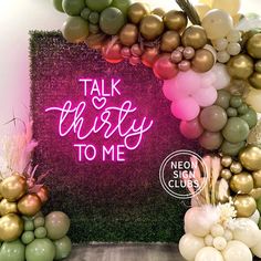 there are balloons and other decorations on the wall in front of this sign that says talk thirsty to me