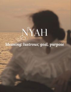 a woman sitting on top of a boat next to the ocean with text that reads, nyah meaning history, goal, purpose