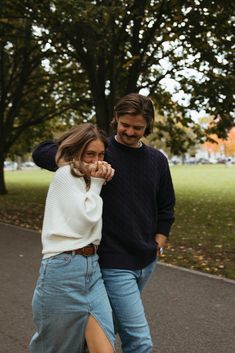 a man and woman are walking down the street with their feet on each other's hips