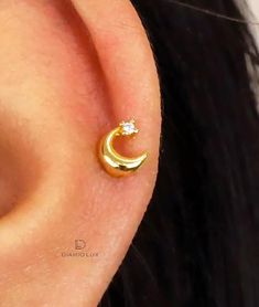 a close up of a person's ear with a small gold nose ring on it