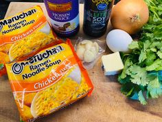 ingredients to make macaroni and cheese soup laid out on a cutting board next to onions, parsley, garlic, onion, butter, and other items