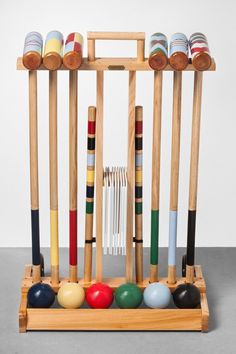 a wooden rack with several different colored croquets on top of it and two forks in the middle