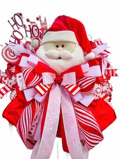 a santa clause wreath with red and white ribbons