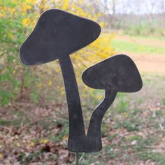 a metal sculpture with two black mushrooms on it