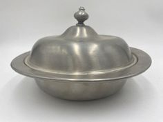 a silver covered dish on a white background