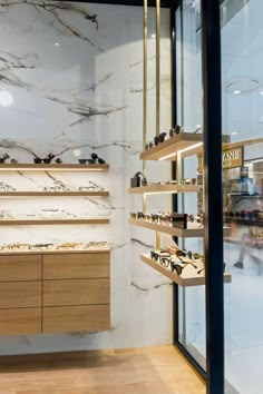 the inside of a store with marble walls and shelves filled with pairs of women's shoes