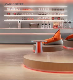 two orange pillows sitting on top of stools in front of a coffee shop counter