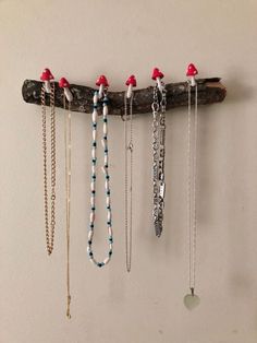 several necklaces are hanging on a wooden branch