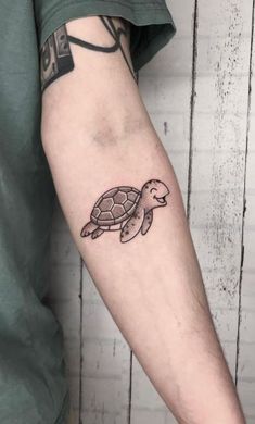 a small turtle tattoo on the arm