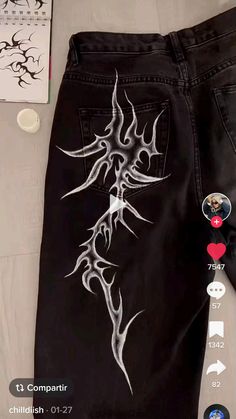 a pair of black jeans with white designs on them