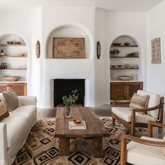 a living room filled with furniture and a fire place in the middle of a room