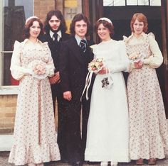 a group of people standing next to each other in front of a building with doors