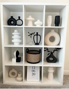 a white shelf filled with vases and other items