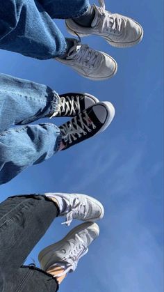 three people standing in the air with their feet up