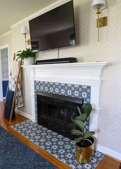 a living room with a fireplace, television and potted plant on the mantel