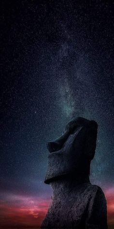 the night sky is filled with stars above a large rock