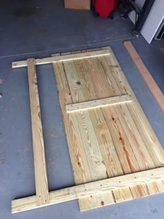 a wooden door frame sitting on top of a floor next to another piece of wood