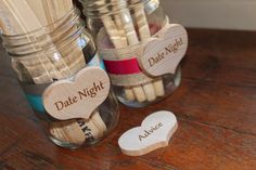 two mason jars filled with matches and wooden hearts