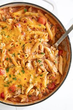 a skillet filled with pasta and meat covered in cheese