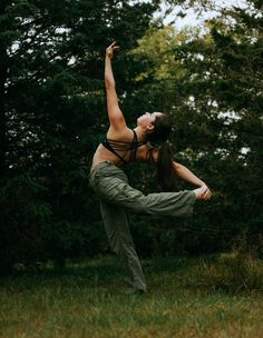 a woman is doing yoga outside in the grass