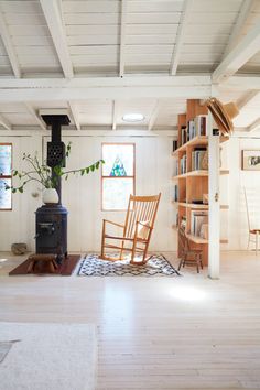 a living room filled with furniture and a wood burning stove top oven next to a book shelf