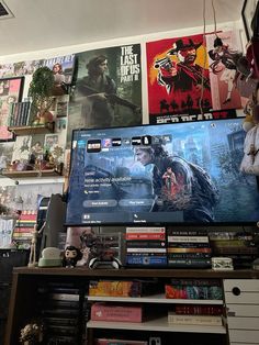 a large flat screen tv sitting on top of a wooden shelf next to a bookshelf