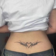 a woman's lower back tattoo with two birds in the shape of a heart