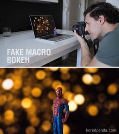 a man holding a camera next to a laptop and spider - man figurine