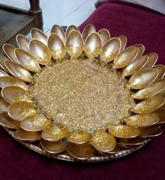 a large metal flower on top of a glass plate with gold flakes in the center