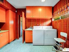 an orange and white laundry room with washer and dryer