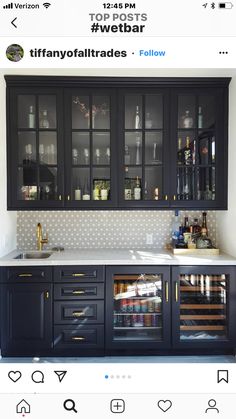 an image of a kitchen with black cabinets and wine glasses on the glass door doors