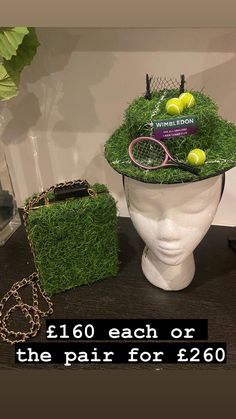 a hat with tennis balls and racquets in it on a table next to a purse