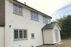 a white house with two windows on the side and one door open to let in light