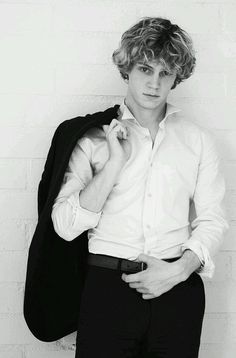 a young man is posing for a black and white photo