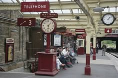 people are sitting on benches at the train station