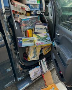 the back door of a van filled with books and magazines on top of each other