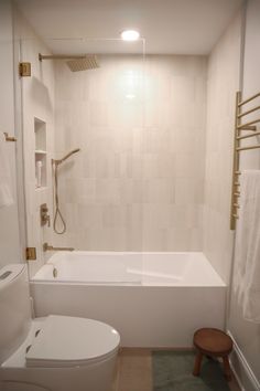 a bathroom with a toilet, tub and shower