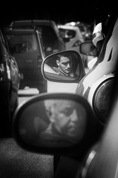 black and white photograph of man in rear view mirror