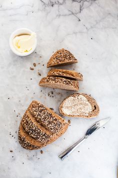 three pieces of bread sitting on top of a table next to a bowl of butter