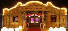 an entrance to a circus with lights on the sides and red carpeted flooring