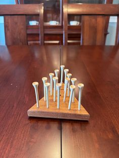 a wooden table topped with lots of white candles on top of it's bases