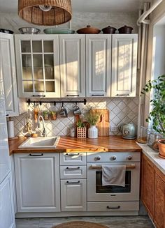 a kitchen with white cabinets and wooden counter tops