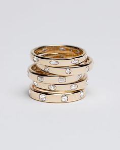 stack of gold rings with diamonds on each one and the other in different sizes, all stacked together