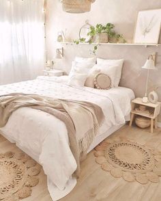 a white bed sitting in a bedroom on top of a hard wood floor next to a window