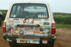 the back end of a vehicle with many stickers on it's bumpers