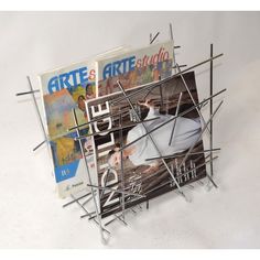 a magazine holder made out of sticks and magazines on top of each other with the cover pulled down