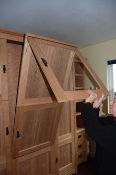 a man is holding up a large piece of furniture